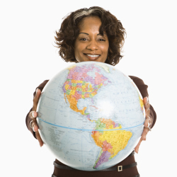 Smiling woman holding out world globe.